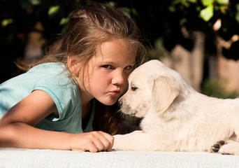 smiling baby girl and golden retriever puppy together