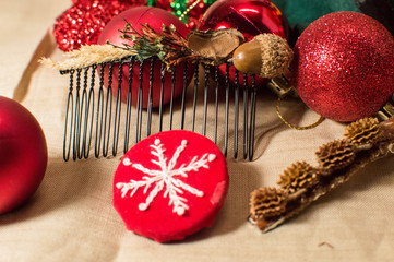 red christmas decorations and homemade  brooch andclasps on linen background