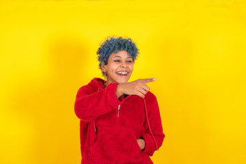 afro american woman isolated on color background pointing by hand