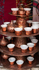 Traditional metal souvenirs at souvenir shop. Copper coffee mugs. Eastern authentic oriental cups.