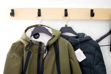 Dressing room in shop. Sports clothes on a hanger hanging on the wall. Try on and choose clothes. Sale in shop. Concept of retail. Waterproof jacket with a hood. © Anton Gepolov