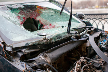 Broken car windshield after an accident with traces of blood and airbag.