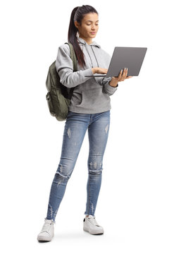 Female student standing and typing on a laptop