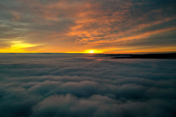 Beautiful sunrise cloudy sky from aerial view. Airplane view above clouds