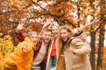 Happy young friends having fun in autumn park