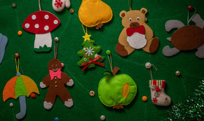 Felt Christmas tree with felt Christmas toys and a garland. Christmas toys: red star, bear, gingerbread, tree, umbrella, mushroom amanita, apple, pear, dove, boot, mittens, turtle.