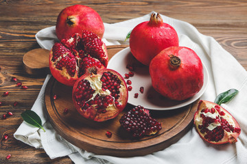 Board with tasty pomegranate on wooden table