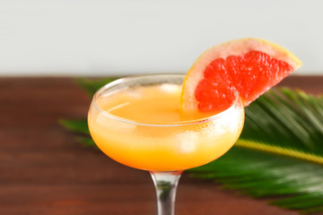 Glass of fresh citrus juice on table