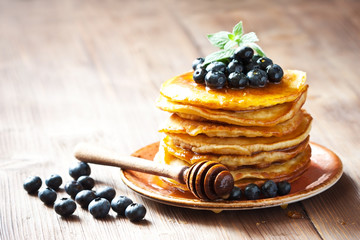  Pancakes with fresh berries and sweet honey on wooden  background