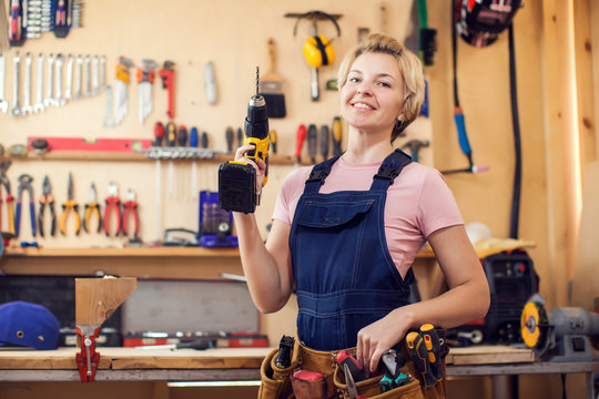 Young Handy Woman With Short Blond Hair Working With Screwdriver.