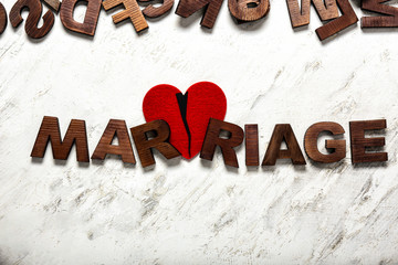 Word MARRIAGE and broken heart on light background. Concept of divorce