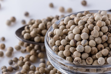 white peppercorns in glass bowl with spoon