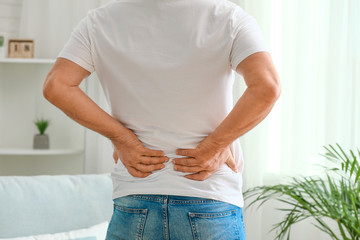 Mature man suffering from back pain at home