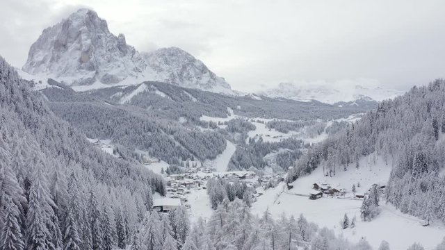 Slope on the Alpine skiing resort Val Gardena in Italy. Mighty Dolomite mountains and forest covered in snow.