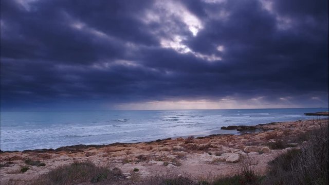 Dark stormy clouds moving over sea water surface, Spain Valencia. Time lapse