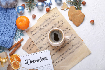 Christmas composition with cup of coffee and music sheets on white background