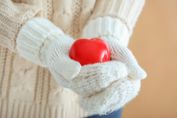 Woman with knitted mittens and red heart, closeup. Valentines Day celebration