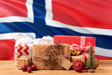 Norway new year celebration theme. Wrapped christmas gifts on waving national flag background. Merry christmas concept.