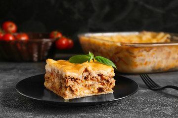 Plate with prepared lasagna on dark table