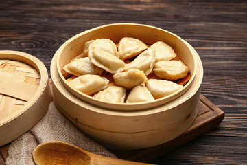 Steamer with tasty dumplings on table