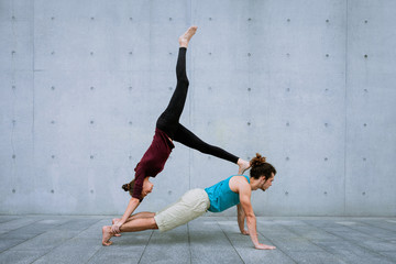 Couple practicing acro yoga outdoors. Acroyoga concept.