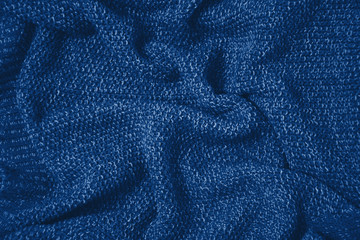 Fototapeta na wymiar Classic blue colour monochrome texture knitted fabric. Blue knitted Jersey as textile background. Classic blue color background. Wool knitting texture. Trendy color 2020.