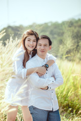 Obraz premium An Asian couple happily go on a honeymoon trip in the mountains.