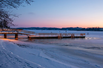 Wonderful winter landscape with snow covered wooden pier, Finland.