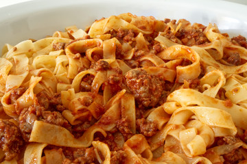 tagliatelle with fresh bolognese ragu in a ceramic bowl. Tagliatelle alla bolognese, traditional italian pasta.