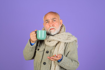 Bearded man holds pills in hand and cup with water. Medicine and health care concept. Healthy lifestyle, medicine, nutritional supplements and people concept. Sick man taking pill. Medicine. Vitamins.