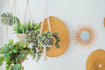 Modern minimal Scandinavian home interior design. Straw round decor with hanging flower pots with...