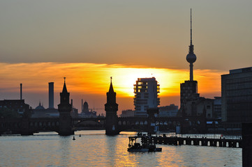Fototapeta premium Silhouette of Berlin in the sunset - with the Oberbaum bridge, television tower and other landmarks of Berlin, Germany. 