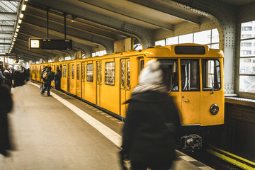 Underground station in Berlin with yellow train and passengers. Public transport in Berlin. Travel...
