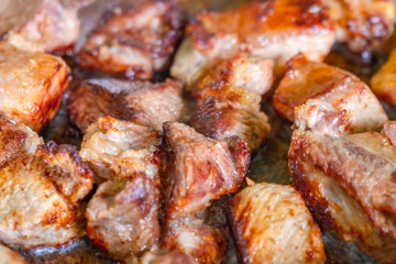 frying pork meat in a pan at home