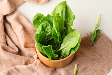 Bowl with fresh spinach on table