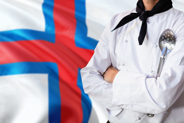 Fototapeta premium Faroe Islands domestic food concept. Professional chef in white uniform is standing with metal spatula. Copy space for text.