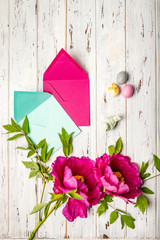 Easter composition: Colourful marzipan eggs, envelopes and pink peonies 