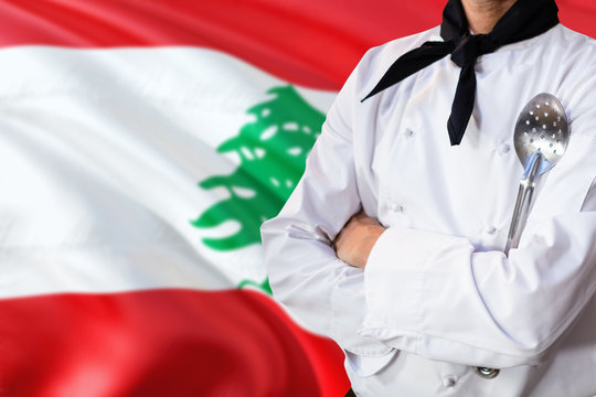 Lebanon domestic food concept. Professional chef in white uniform is standing with metal spatula. Copy space for text.