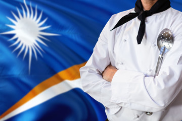 Marshall Islands domestic food concept. Professional chef in white uniform is standing with metal...