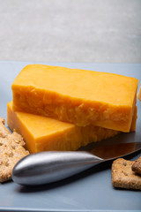 Cheese collection, matured and orange original British cheddar cheese in blocks served on grey plate