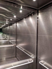 Infinite mirrors in an elevator with lights and metal walls. © Ian
