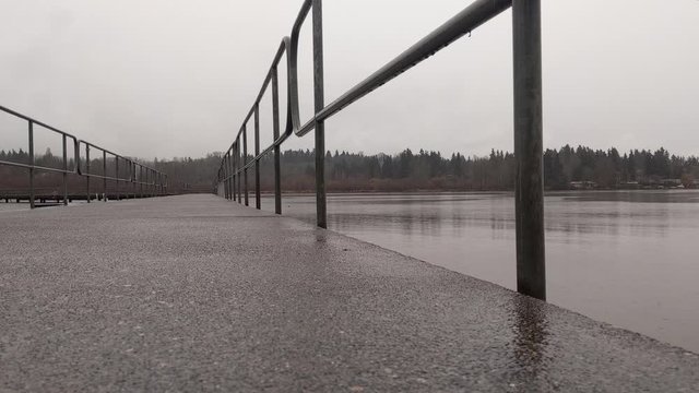 Low Angle View Of Heavy Rain On A Boardwalk Out On Lake Washington On An Overcast Day