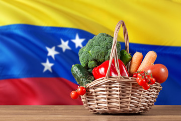 Venezuela organic food concept. National flag background with basket full of vegetables on wooden...