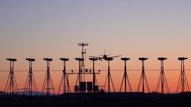 4K footage of an airplane while landing at an international airport during sunset.