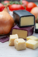 Mini black and dark red waxed cheddar cheeses with strong flavor made from West Country milk and and age-old methods with onion and garlic in England