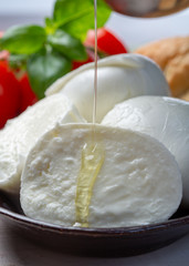 Balls and pieces of buffalo mozzarella, soft Italian scheese made from the milk of Italian Mediterranean buffalo