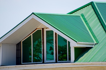 The house with plastic windows and a green roof of corrugated sh