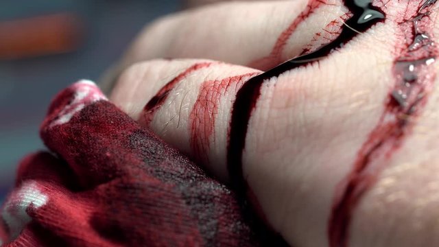 Blood dripping overy fingers and hand macro isolated extreme close up blood soaked rag