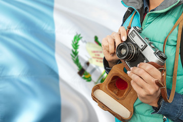 Guatemala photographer concept. Close-up adult woman holding retro camera on national flag...