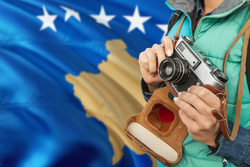 Kosovo photographer concept. Close-up adult woman holding retro camera on national flag background....